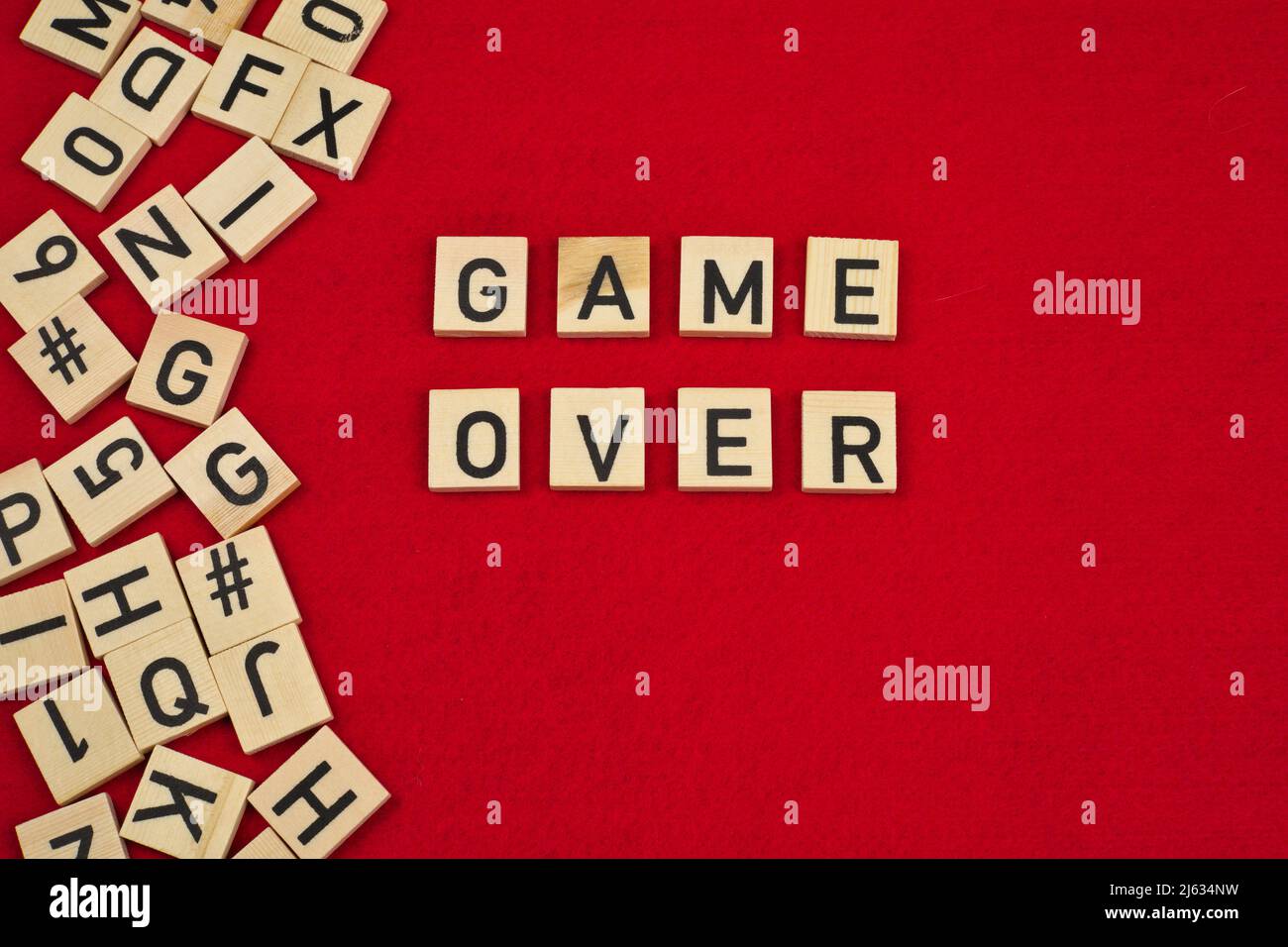 Frase "Game Over" su sfondo rosso feltro circondato da piastrelle di legno lettera Foto Stock
