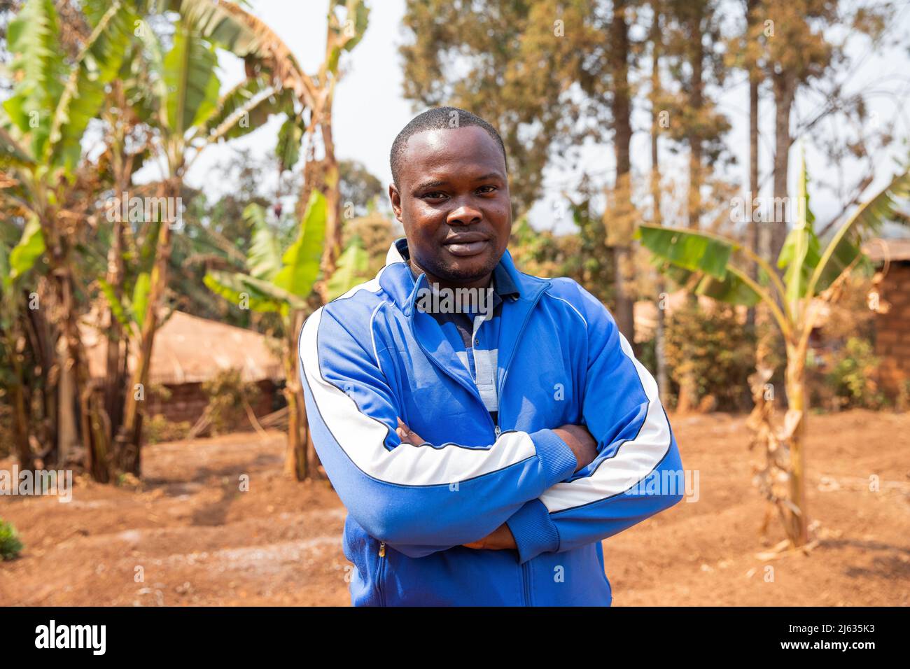 Ritratto di un giovane africano in un campo coltivato in africa, uomo d'affari posa guardare la macchina fotografica, agricoltore africano Foto Stock