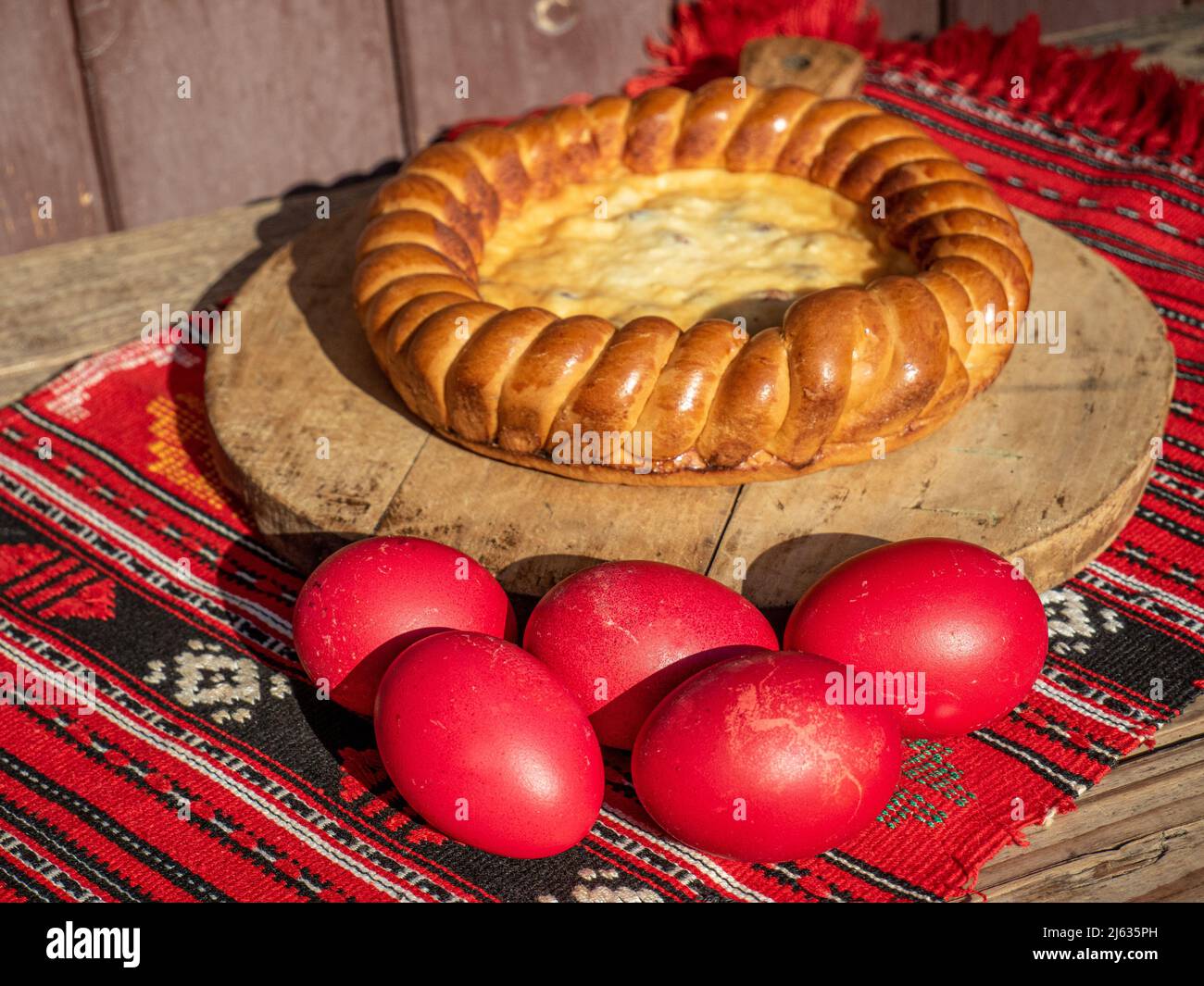 uova rosse di pasqua e pane dolce conosciuto come pasca in rumeno Foto Stock