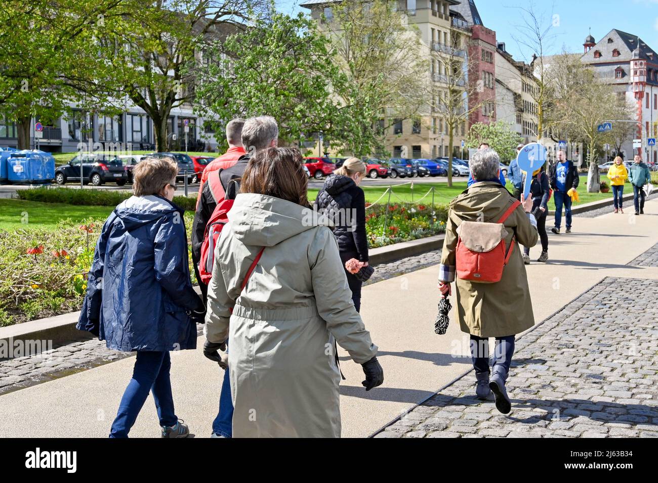 Coblenza, Germania - Aprile 2022: Guida turistica che tiene un cartello per TUI River Cruises che conduce un gruppo di turisti attraverso la città Foto Stock