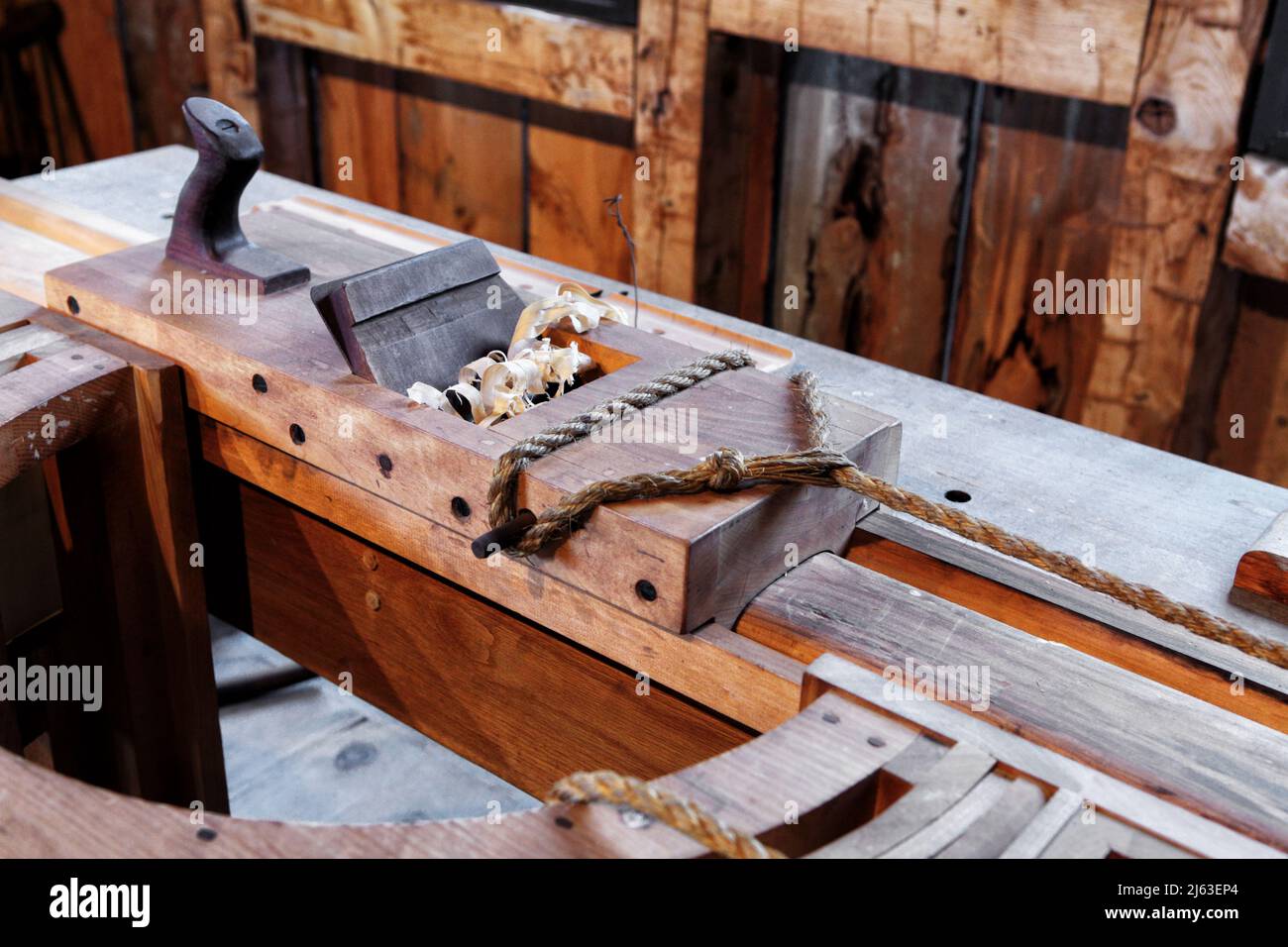 L'interno di un negozio di legno d'epoca, con un'antica pialla a forma di lucciola in mostra. Foto Stock