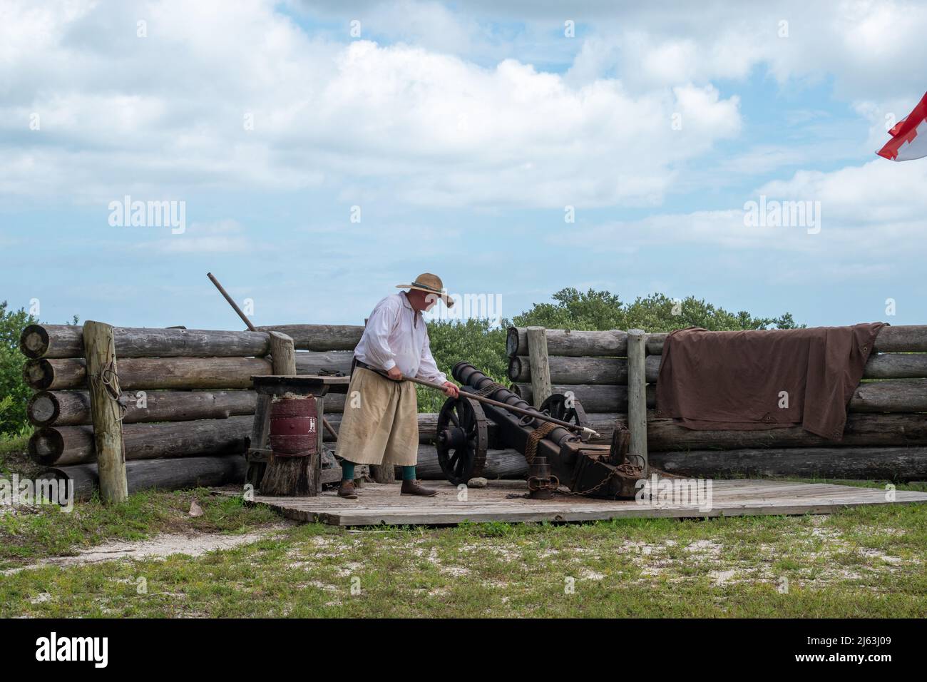 Un maschio bianco che indossa panni in stile spagnolo sparando un cannone in una rievocazione storica Foto Stock