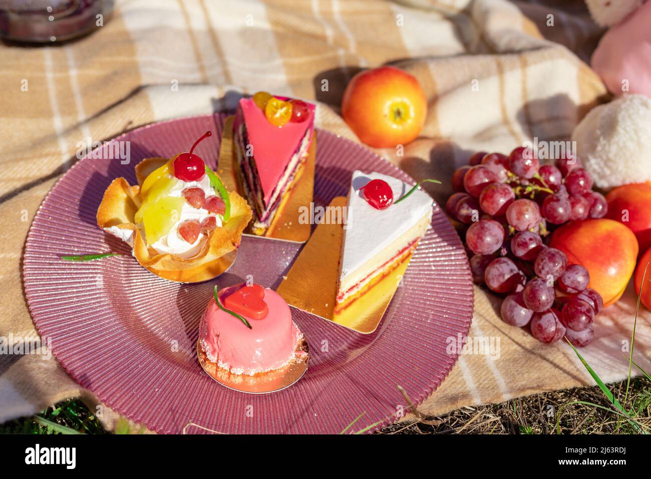 Composizione su un copriletto di dolci, uva e pesche Foto Stock