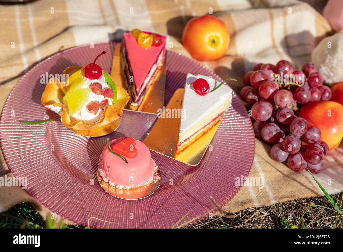 Composizione su un copriletto di dolci, uva e pesche Foto Stock