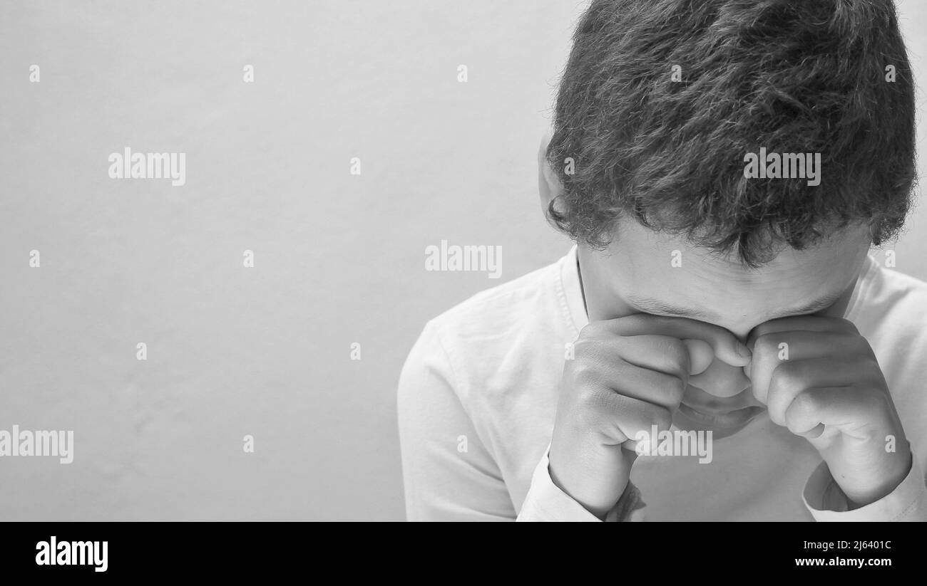 Bambino che prega a Dio con le mani insieme alla gente foto di scorta Foto Stock