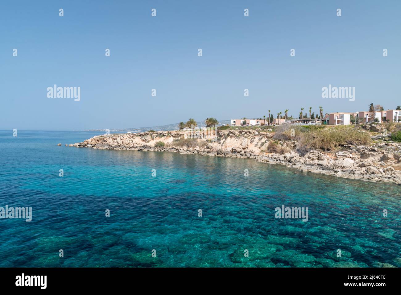 Costa rocciosa con acque cristalline e blu sul mare Mediterraneo. Spiaggia di Chloraka, Cipro. Foto Stock