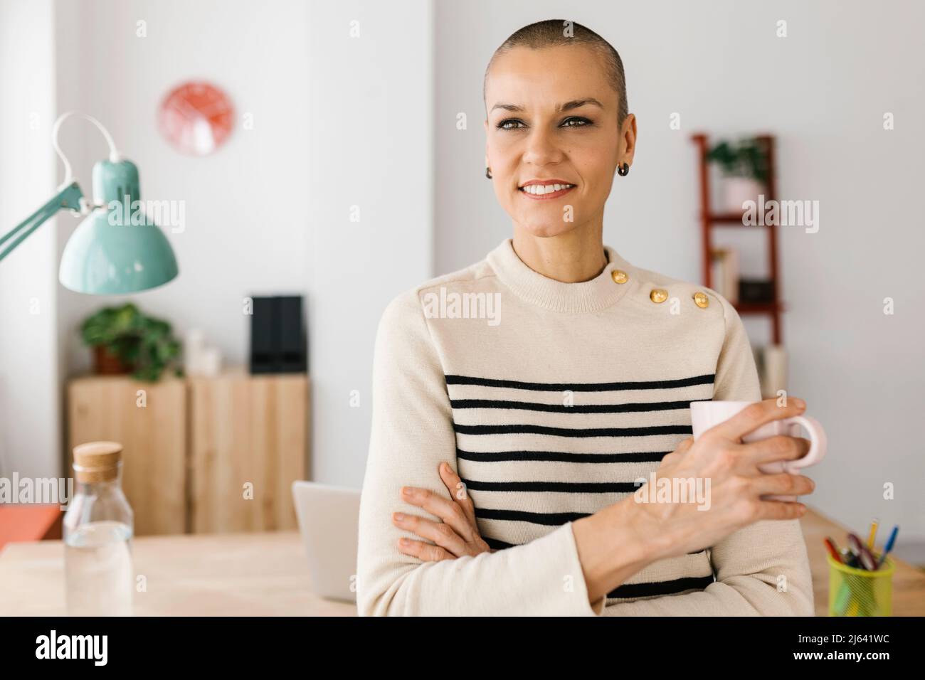 Donna di affari giovane di successo in piedi nel suo ufficio domestico Foto Stock