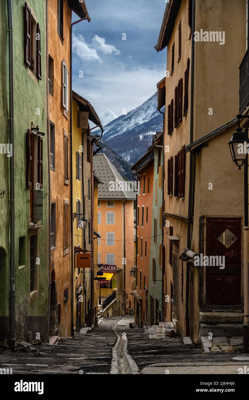 Briancon, Francia - 15 Mar 2022: Strada medievale colorata a Briancon con vista sul monte Serre Chevalier; strade più belle della terra carta da parati Foto Stock