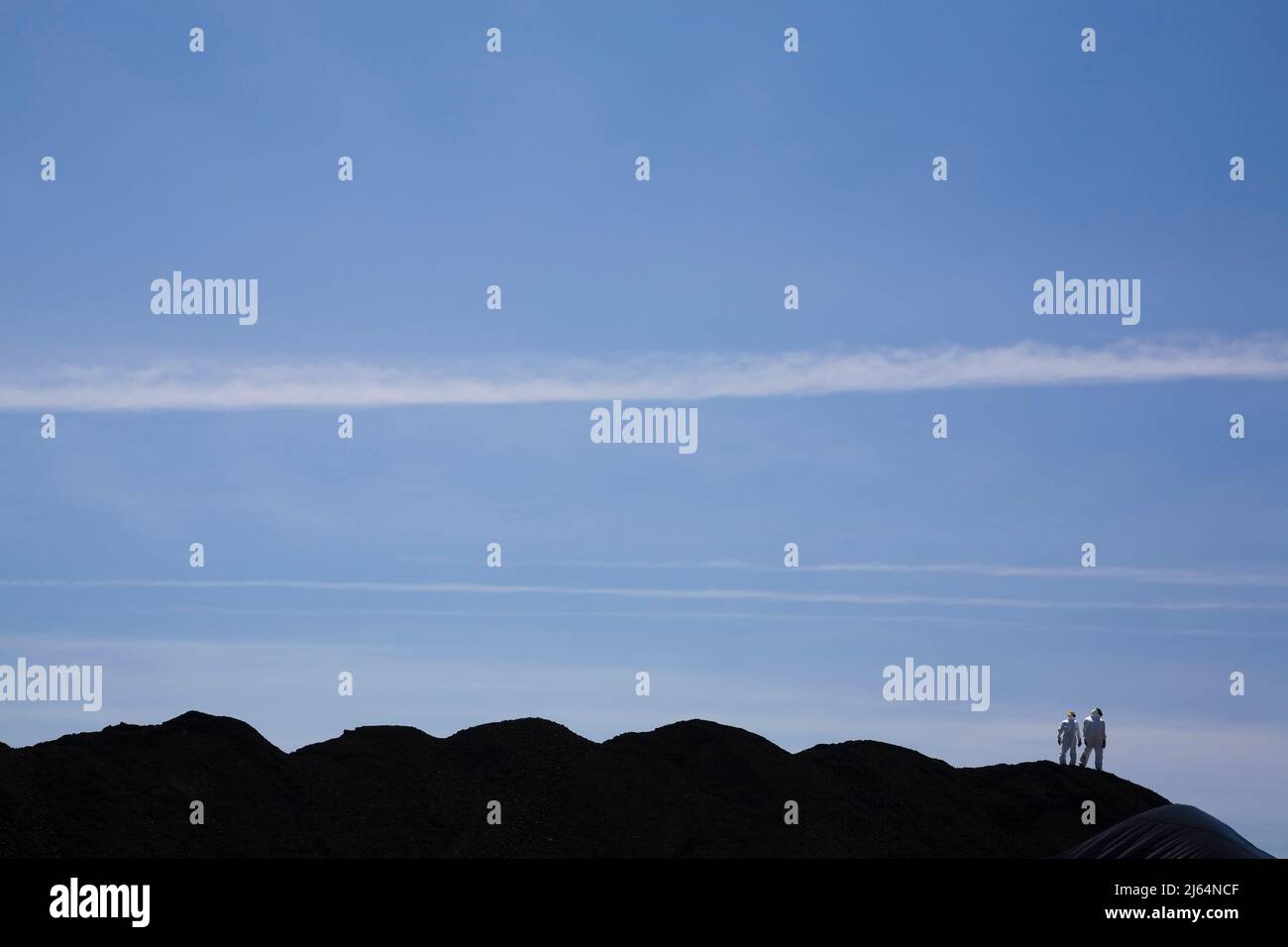 Due lavoratori che indossano tute protettive sopra il cumulo di carbone, Porto di Quebec, Canada Foto Stock