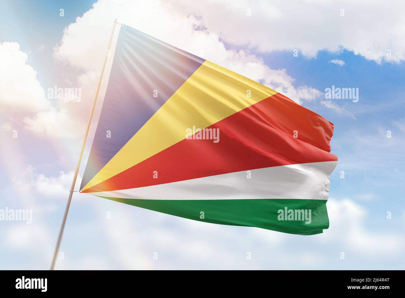 Cielo azzurro soleggiato e un flagpole con la bandiera delle seychelles Foto Stock
