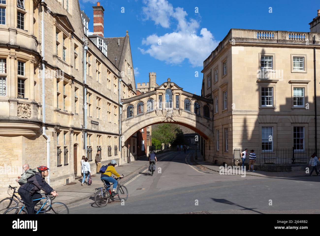 I ciclisti si accinzettono a passare sotto il Ponte dei Sospiri; una sopraelevata che collega due parti dell'Hertford College di Oxford Foto Stock