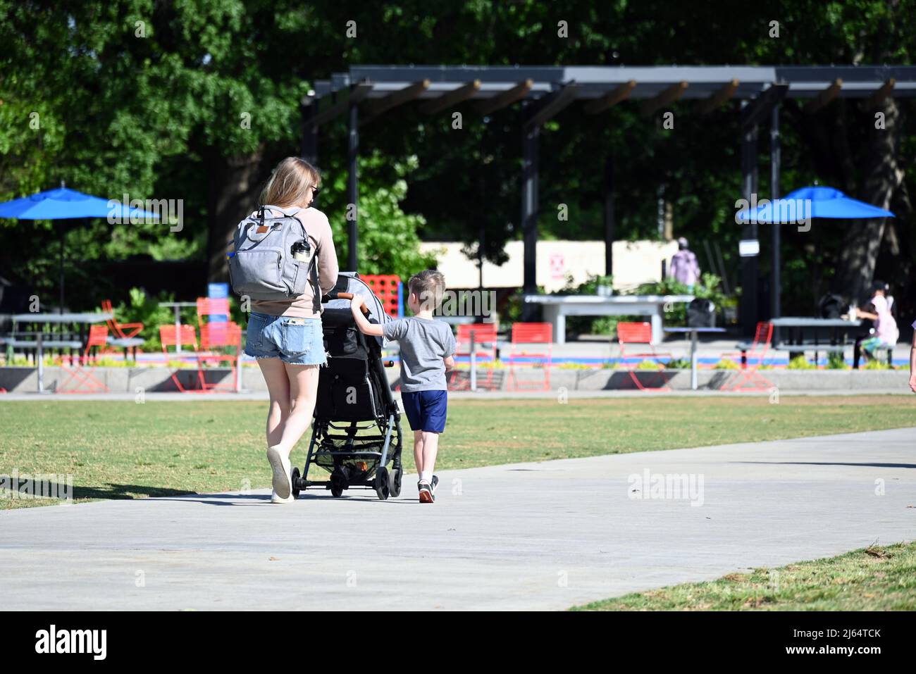 Una madre cammina con suo figlio giovane nel parco al largo del centro di Raleigh, Carolina del Nord. Foto Stock