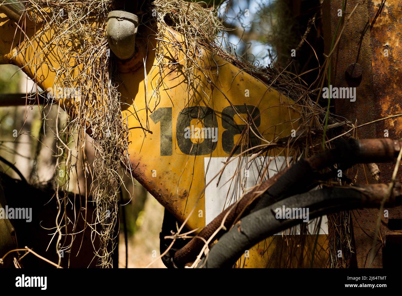 attrezzatura agricola arrugginente gialla con numeri 108 verniciata sul lato Foto Stock