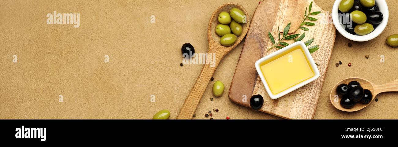 Ciotola di olio e gustose olive con spezie su sfondo colorato con spazio per il testo Foto Stock