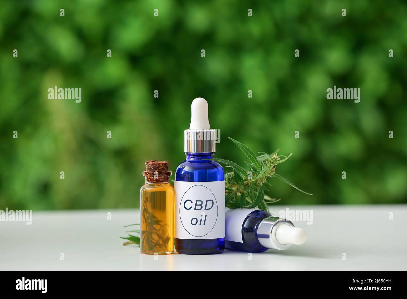 Bottiglie di olio CBD sul tavolo all'aperto Foto Stock