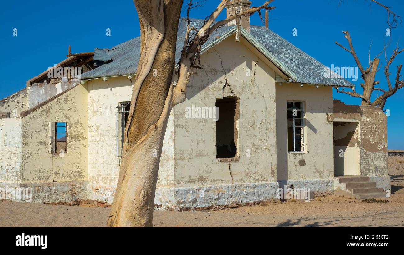 L'ex stazione ferroviaria si è sgretolata in una zona solitaria di Garub, nel sud della Namibia, in Africa. Si tratta di un edificio bianco vuoto e dilapidato, con sabbia deserta Foto Stock