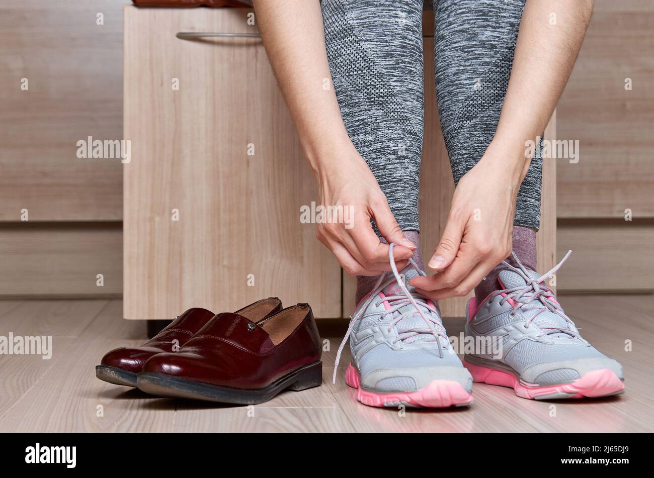 Donna che cambia scarpe prima dell'allenamento. Foto Stock