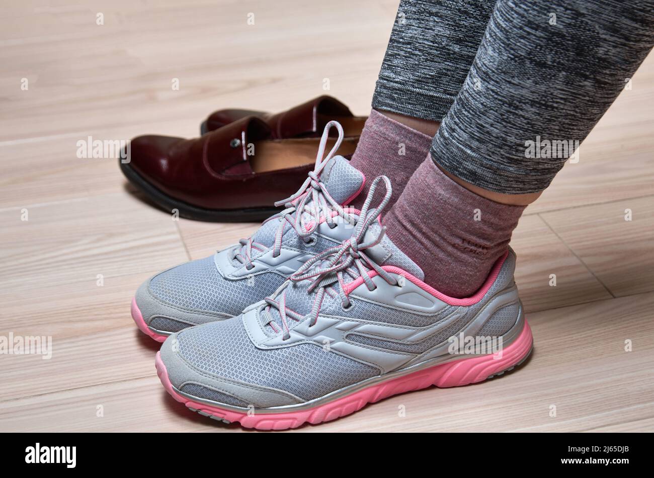 Donna che cambia scarpe prima dell'allenamento. Foto Stock