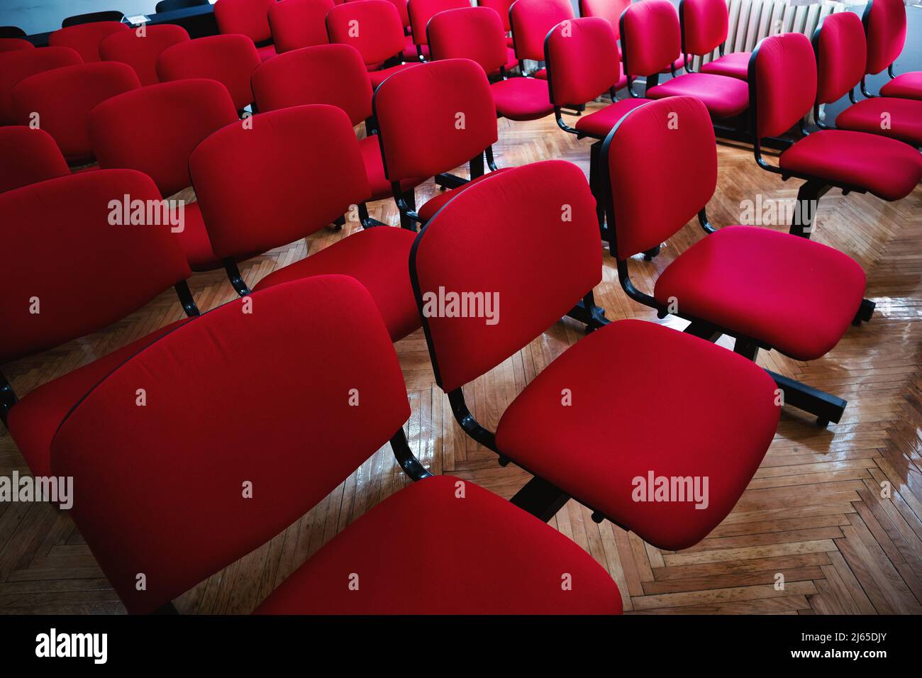 Interno di un'aula con sedie rosse. Foto Stock