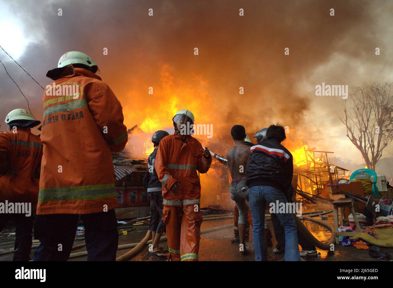 Membri dei vigili del fuoco e residenti che combattono un incidente d'incendio in un quartiere denso di Penjaringan, Giacarta Nord, Giacarta, Indonesia. Foto Stock