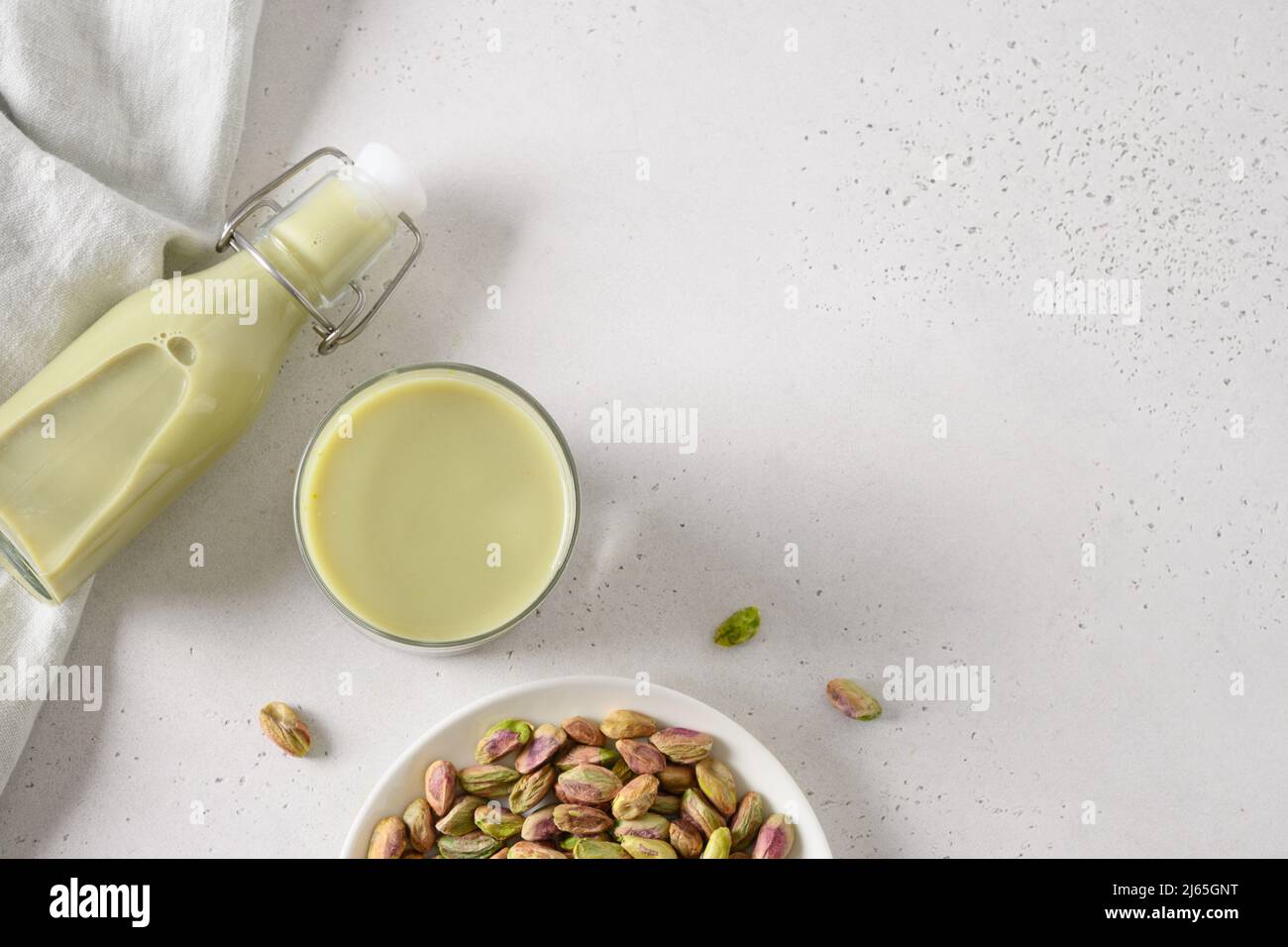 Latte di Pistacchio sano su sfondo bianco. Orientamento orizzontale. Vista dall'alto. Spazio di copia. Latte vegetale vegano a base di noce. Foto Stock