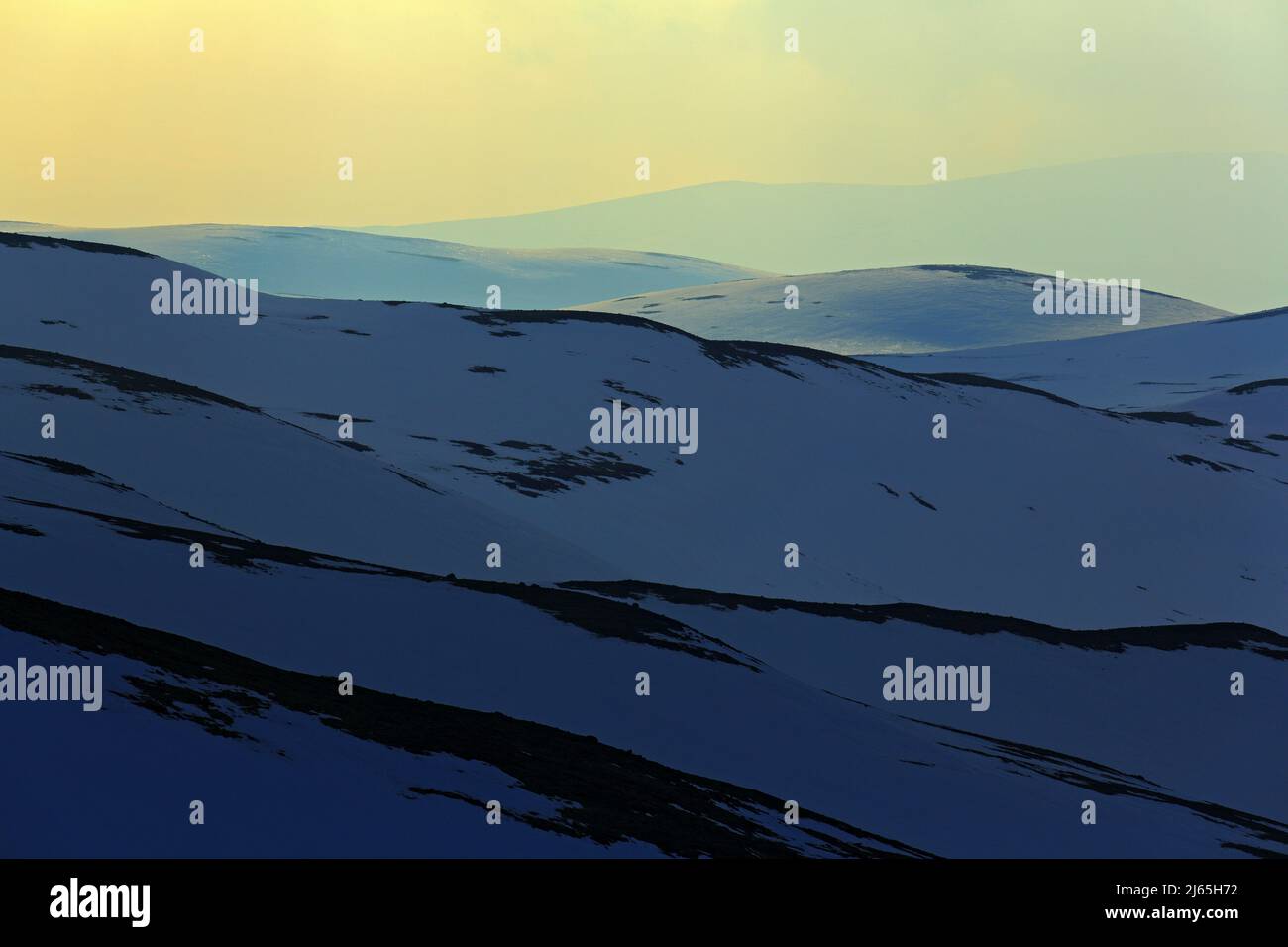 Vista panoramica del paesaggio montano al tramonto, campo di neve bianca pura, cielo giallo, nuvole bianche, Norvegia. Foto Stock