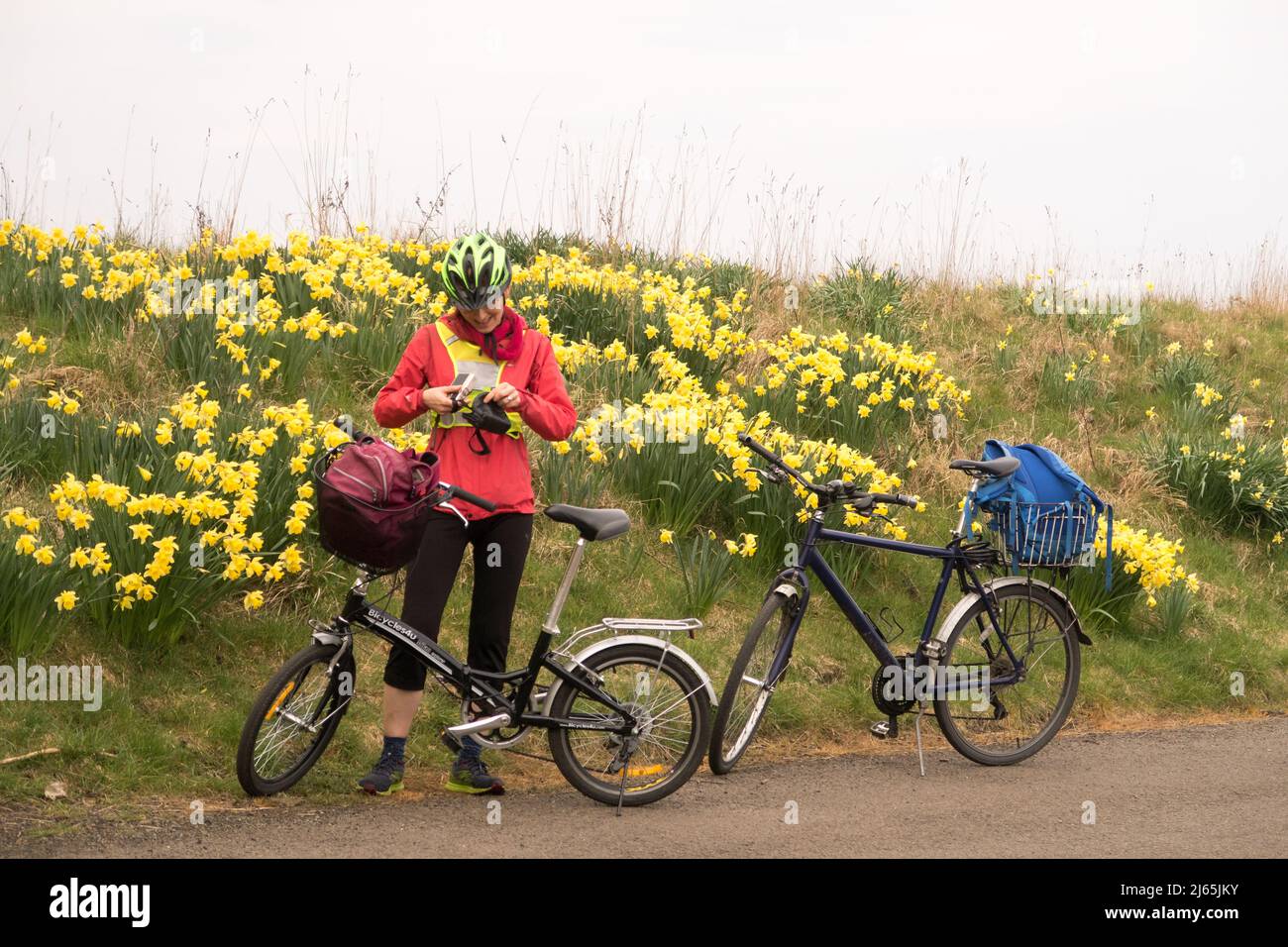 Una donna con la sua bicicletta pieghevole pronta a andare in bicicletta lungo un percorso Foto Stock