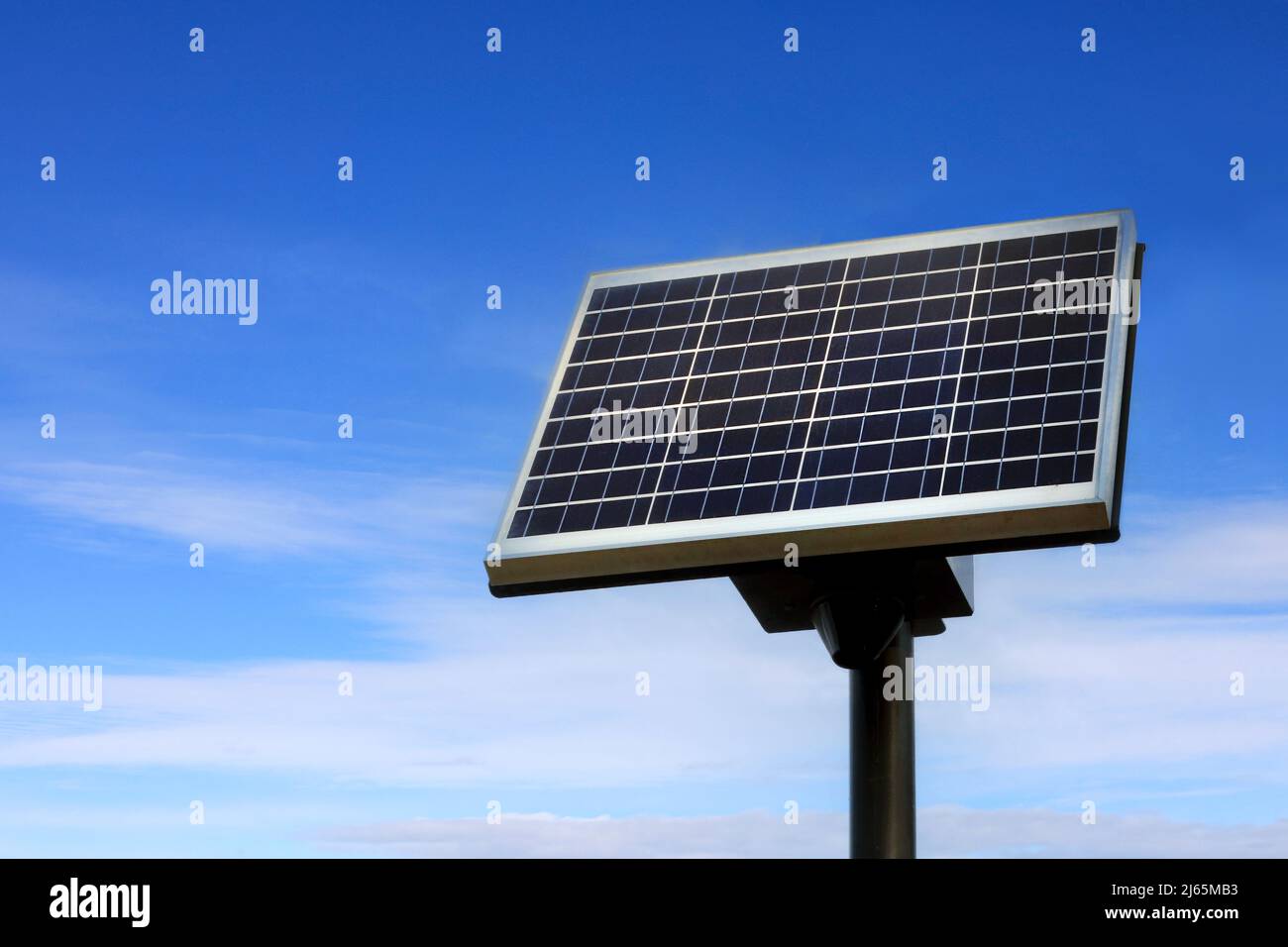 Piccolo pannello solare contro il cielo blu con alcune nuvole bianche, copia lo spazio a sinistra dell'immagine. Foto Stock