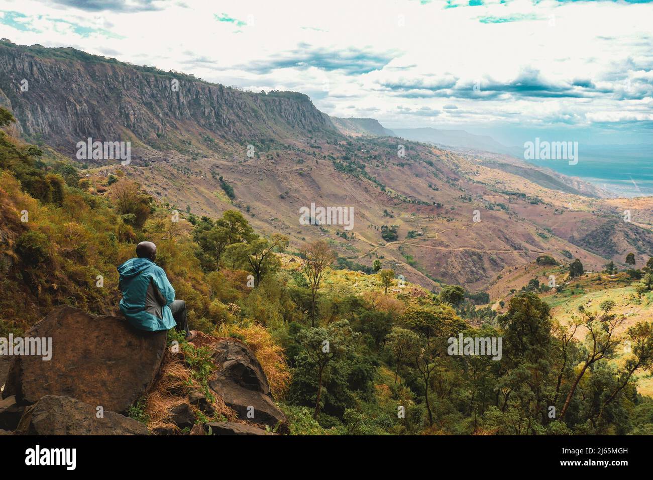 Vista posteriore di un uomo in piedi in un punto di vista della valle di Kerio, Elgeyo Marakwet, Kenya Foto Stock