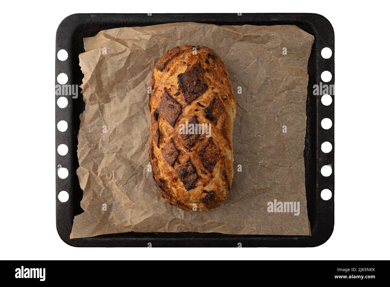 vista dall'alto del pane fresco fatto in casa con crosta croccante dorata su pergamena e foglio da forno isolato su pane bianco biologico con primo piano di cipolla Foto Stock
