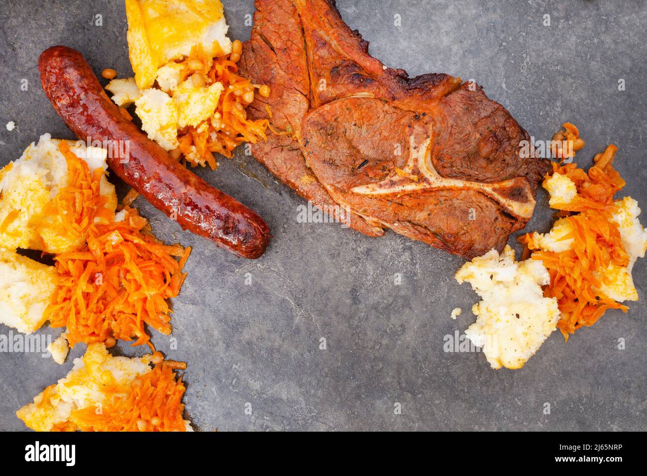 Piatto di Braai tradizionale sudafricano o Shisa nyama, carne cotta a fiamma libera e contorno tradizionale di pap e chakalaka. Foto Stock
