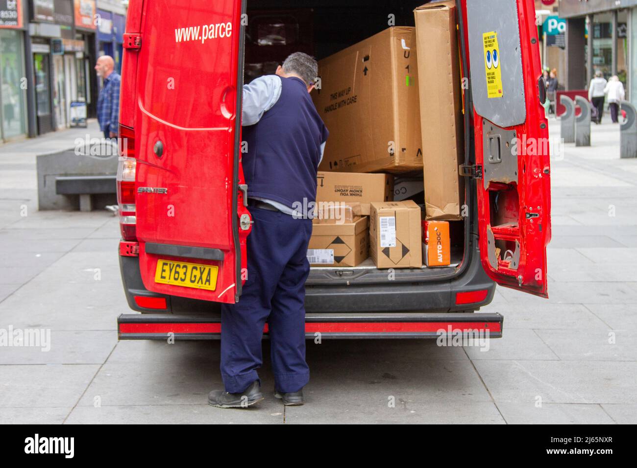 Consegna a pieno carico Express Parcel Force (Parcelforce Worldwide). Postman per Royal Mail veicolo con pacchi fragili, 'questo modo up' scatole sono consegnati a Southport, Regno Unito Foto Stock