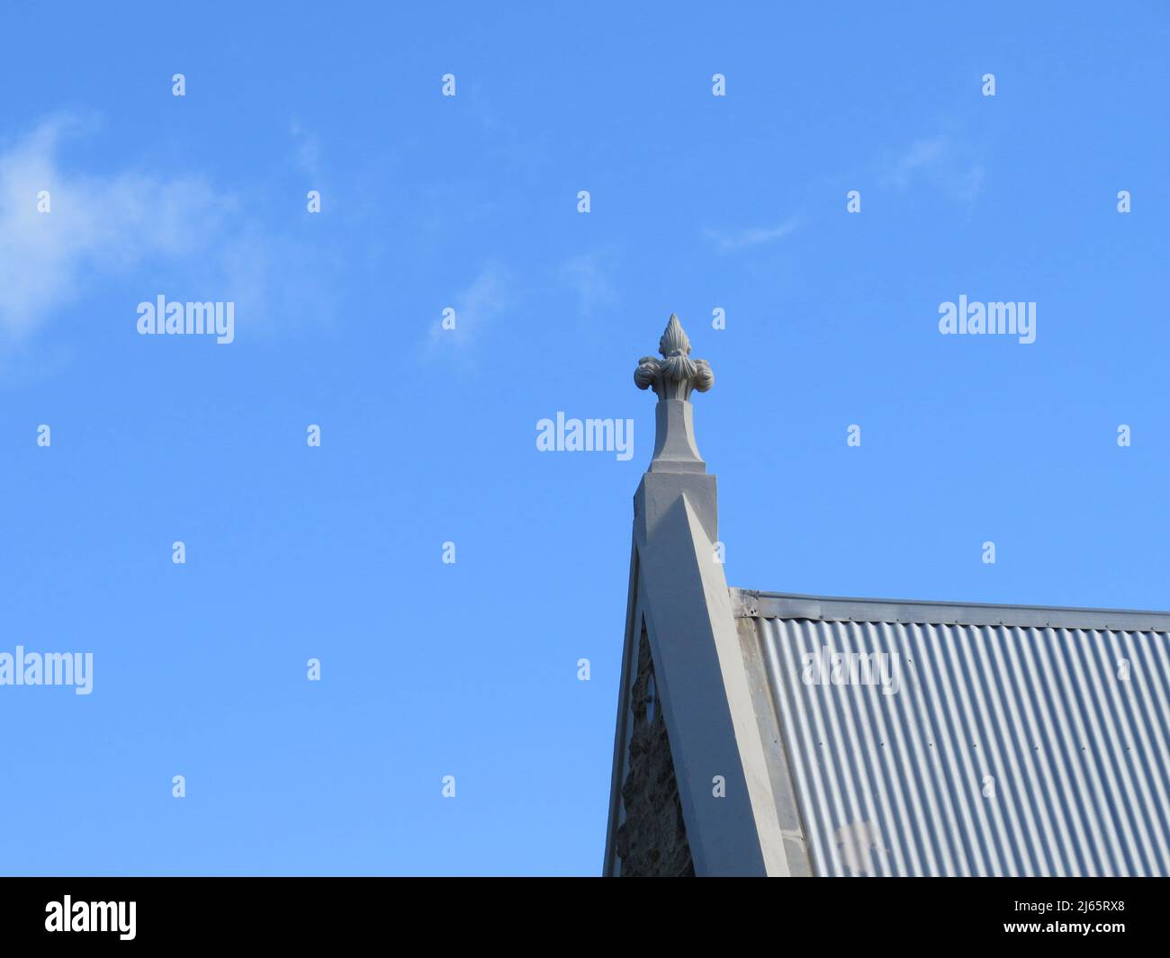 Una guglia soletta della chiesa pierce il cielo azzurro, che punta al cielo. Foto Stock