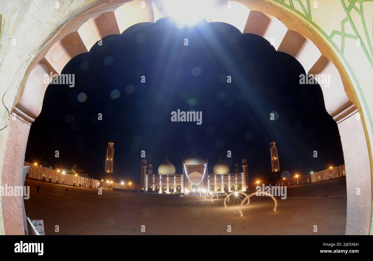 Una splendida e attraente vista aerea della storica moschea Badshahi dell'era Mughal decorata con luci per segnare la notte Santa e cercare le benedizioni divine di Lailatul Qadr, anche conosciuta come la Notte del potere a Lahore. Laylat ul Qadr o comunemente noto come Shab-e-Qadr, la "Notte del potere" è piena di benedizioni perché l'eminente Corano discese in esso, i fedeli musulmani arrivano ad offrire preghiere serali 27th notte del mese Santo del Ramadan in una Moschea Badshahi illuminata" secondo la tradizione, Quando il libro sacro musulmano, il Corano, fu rivelato al profeta Maometto attraverso l'angelo Gabrie Foto Stock