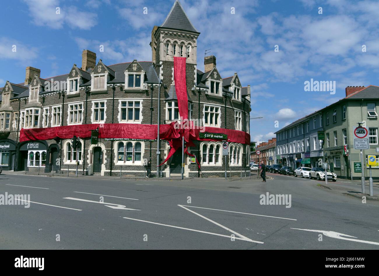 The Corporation Public House, all'angolo tra Cowbridge Road East e Llandaff Road, Canton, Cardiff. Avvolto con un nastro rosso e arco. La Corp Foto Stock