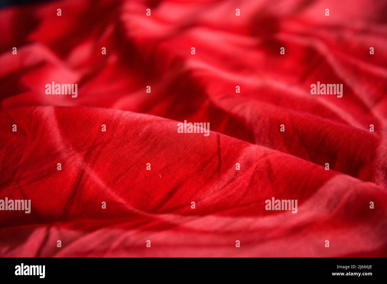 Tessuto rosso stropicciato. Sfondo luminoso e colorato per il design. Foto Stock