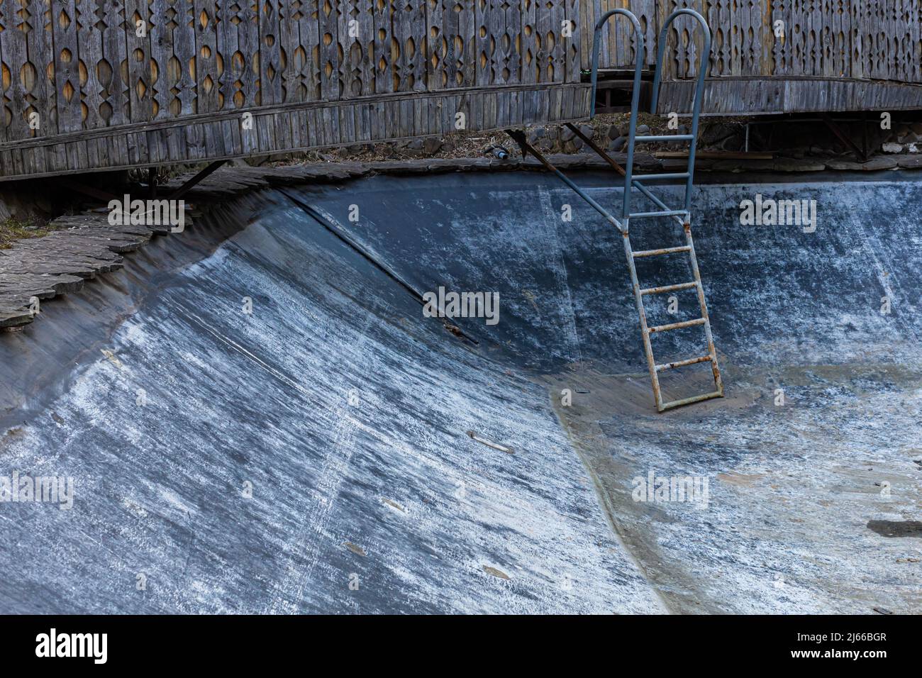 lo spazio di una vecchia piscina vuota con una scala che scende in essa. Foto di alta qualità Foto Stock