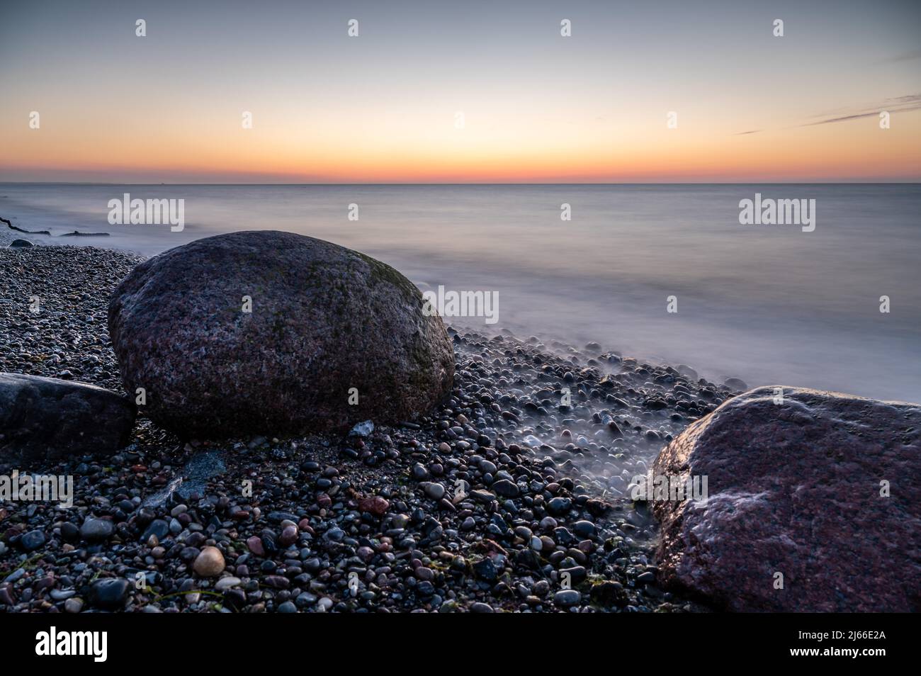 Langzeitbelichtung von grossen Felsbrocken am steinigen Strand der Ostsee bei Sonnenuntergang, Ostseebad Nienhagen, Mecklenburg-Vorpommern Foto Stock