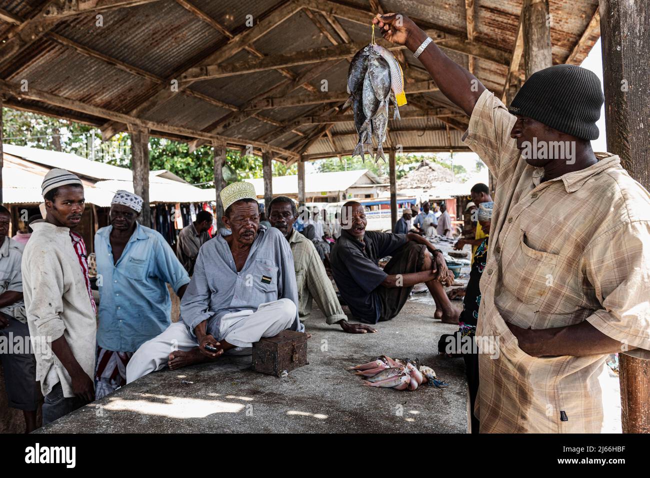 Mann verkauft Fische, Kunden, Fischmarkt in Mkokotoni, Unguja, Sansibar, Tansania Foto Stock