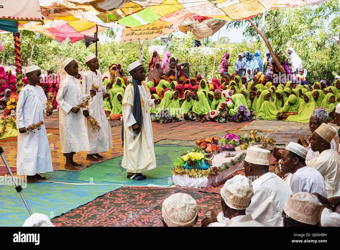 Jungen, Maenner und hinten Frauen bei Muslimische Feier unter Zeltdach zum Geburtstag Mohammeds auf Tumbatu, Sansibar, Tansania Foto Stock