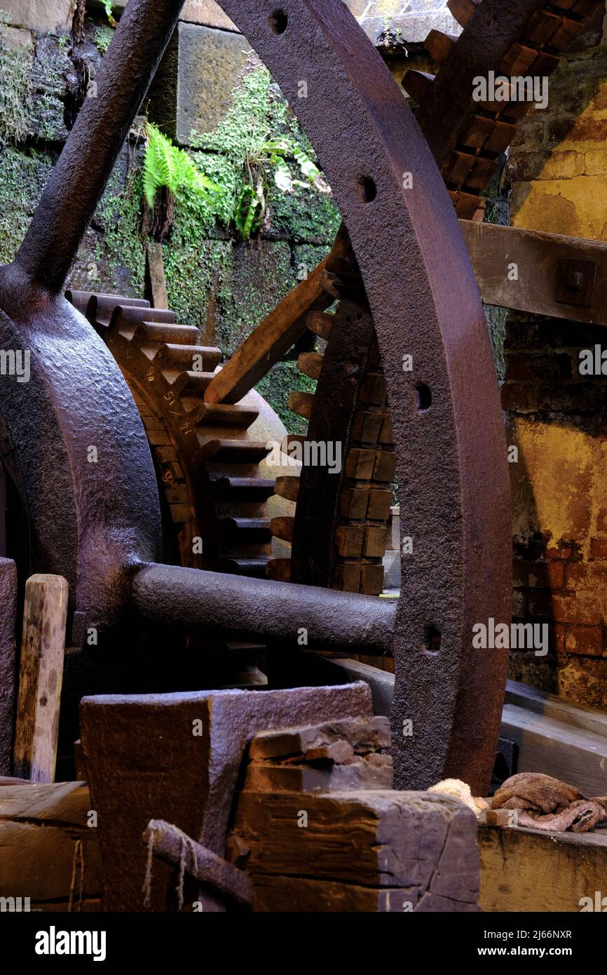Le gigantesche ruote dentate arrugginite poggiano accanto a una vecchia ruota d'acqua a Abbeydale Industrial Hamlet, Sheffield Foto Stock Le gigantesche ruote dentate arrugginite poggiano accanto a una vecchia ruota d'acqua a Abbeydale Industrial Hamlet, Sheffield Foto Stock