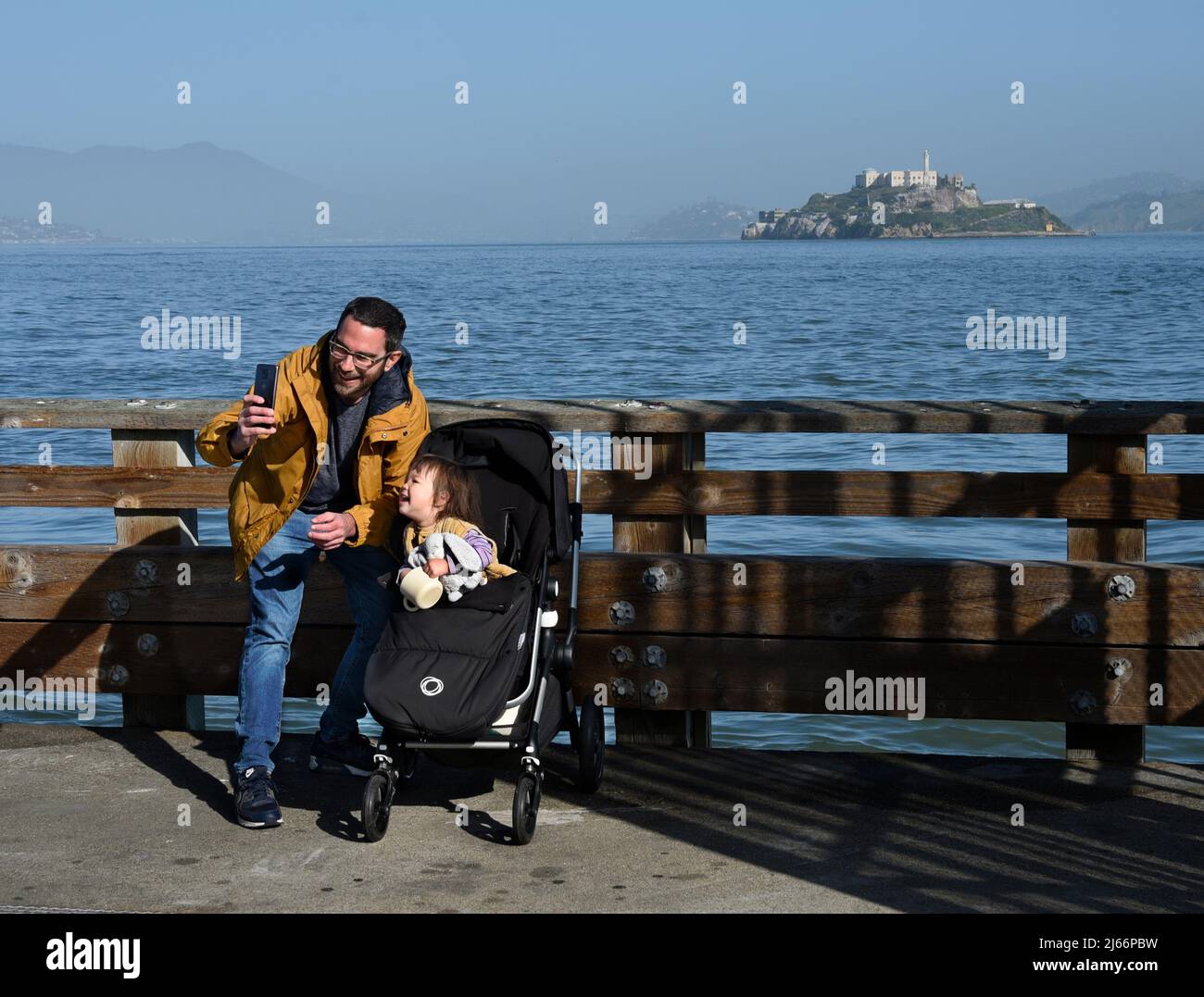 Un giovane padre prende un ritratto selfie di se stesso e sua figlia mentre visitano il distretto del Fisherman's Wharf di San Francisco, California. Foto Stock
