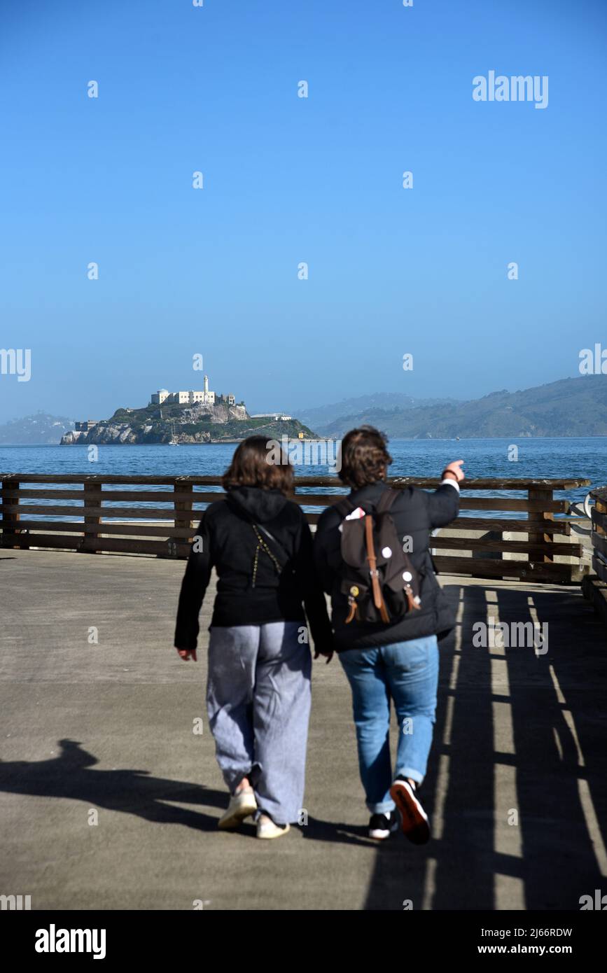 I turisti fanno una sosta su un molo per guardare e fotografare l'attrazione dell'isola di Alcatraz e la sua famosa prigione a San Francisco, California. Foto Stock