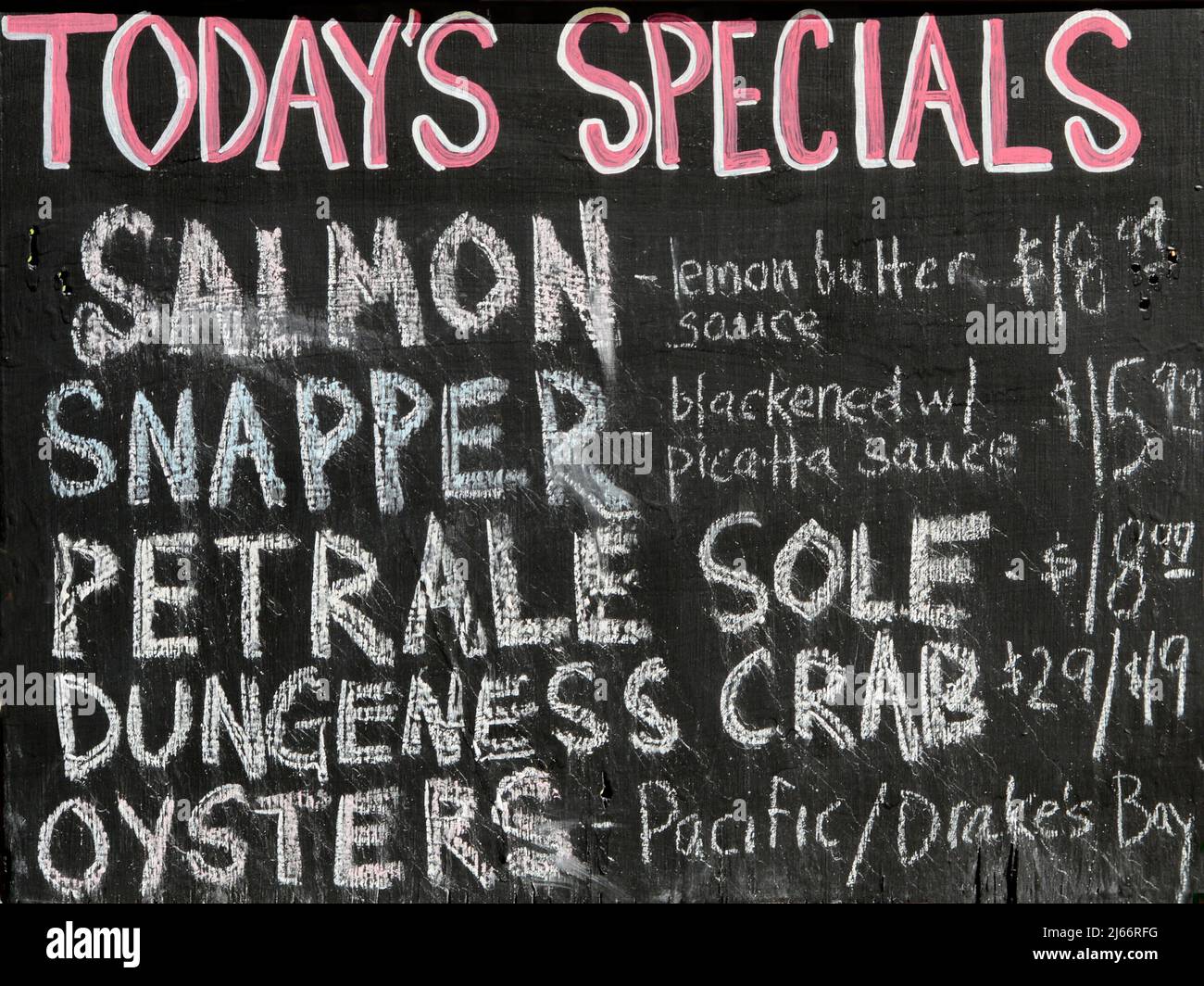 Un turista guarda il menu della lavagna mostrando le specialita' del giorno in un ristorante di pesce nel quartiere Fisherman's Wharf di San Francisco, California. Foto Stock