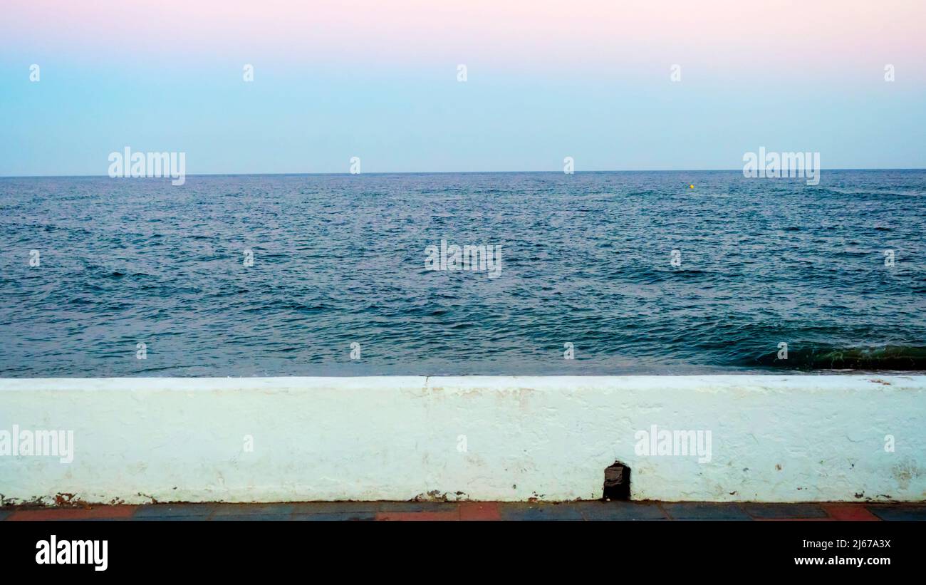 Mare calmo su una spiaggia di Malaga al tramonto Foto Stock