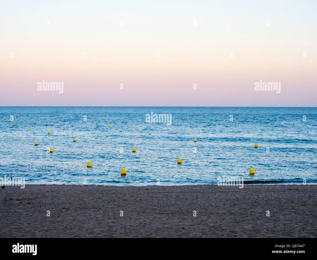 Mare calmo su una spiaggia di Malaga al tramonto Foto Stock
