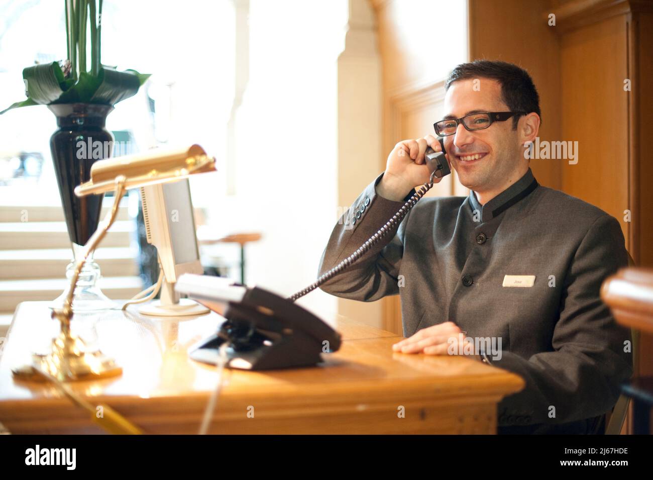 Concierge che parla al telefono in un hotel di lusso a 5 stelle Foto Stock