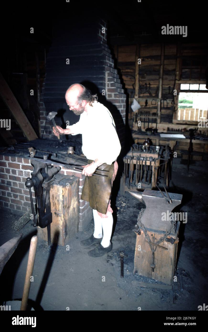 Williamsburg, Virginia. USA 9/1987. Maestri fabbri per il Colonial Williamsburg. Questi smiths artigianale a mano i fissaggi di metallo usati da altri artigiani Colonial Williamsburg quali il wheelright, i fissaggi domestici quali le unghie, le cerniere e le chiusure; e, il secchio di cooper e le cinghie di barile più l'attrezzatura e la riparazione dell'azienda agricola. Foto Stock