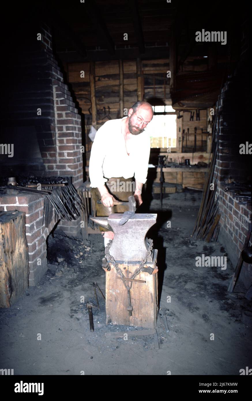 Williamsburg, Virginia. USA 9/1987. Maestri fabbri per il Colonial Williamsburg. Questi smiths artigianale a mano i fissaggi di metallo usati da altri artigiani Colonial Williamsburg quali il wheelright, i fissaggi domestici quali le unghie, le cerniere e le chiusure; e, il secchio di cooper e le cinghie di barile più l'attrezzatura e la riparazione dell'azienda agricola. Foto Stock