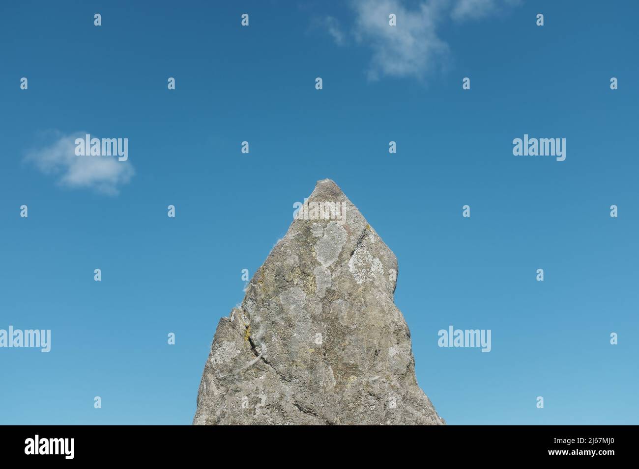 Immagine minimalista di una roccia a forma di freccia che punta in Un vivace cielo blu, con Copy Space Foto Stock